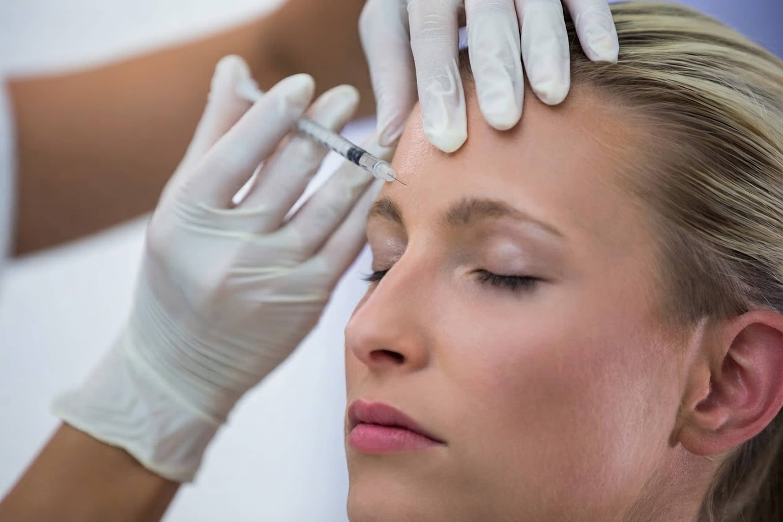 A patient receiving a Botox injection in the forehead at the Rego Park studio