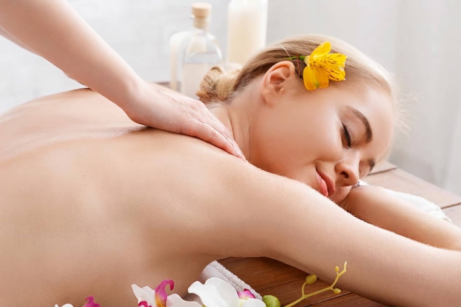 A licensed massage therapist working on a client's shoulders